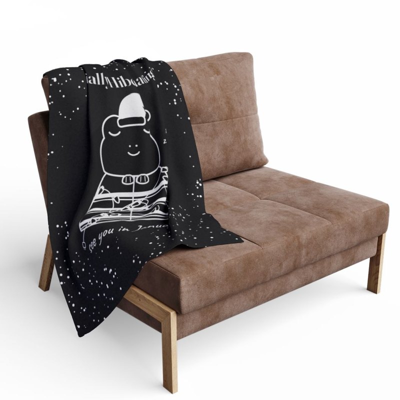 Fleece throw printed edge to edge with the Socially Hibernating Christmas frog in black and white, draped over a chair