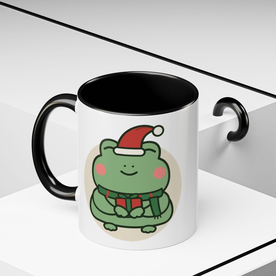 White mug with a black handle, printed with the Christmas frog in a Santa hat